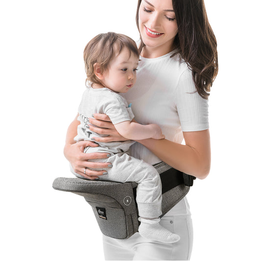 Mom using a collapsible hip seat carrier to hold her child comfortably while keeping hands free.